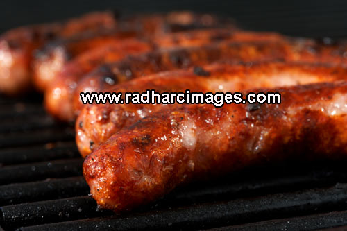 organic sausages cooking on the BBQ
