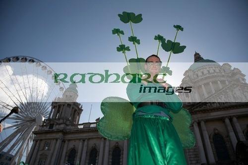 stiltwalker dressed in green wearing shamrocks at belfast city hall and big wheel before the parade and carnival on st patricks day belfast northern ireland