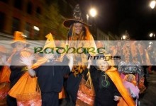 schoolchildren and teachers dressed as orange pumpkins parade down shipquay street Halloween Derry Ireland