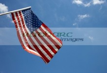 us american flag on flagpole against blue cloudy sky usa