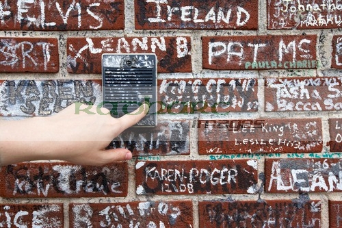 womans hand pushing old intercom button on wall covered in graffiti outside graceland memphis tennessee usa