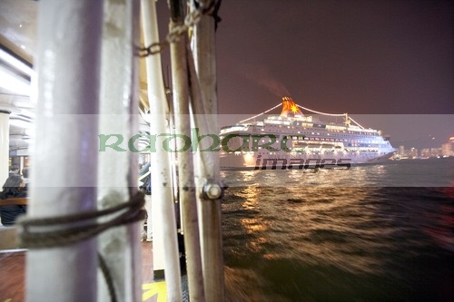 star ferry passing behind large star cruises cruise ship in busy victoria harbour hong kong hksar china asia - deliberate motion blur